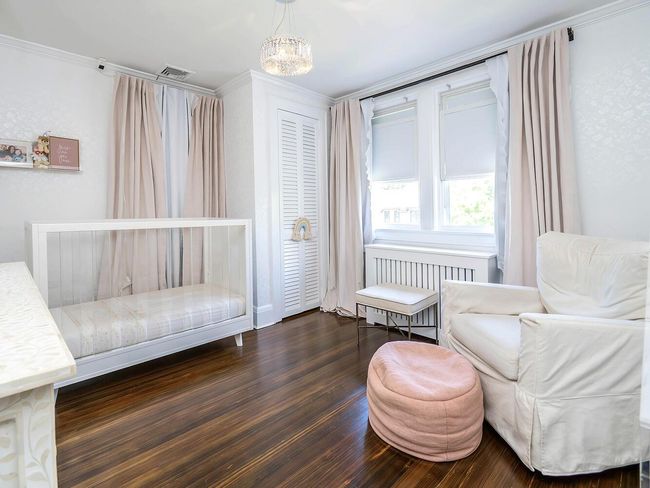 Bedroom featuring radiator, ornamental molding, wood finished floors, and a chandelier | Image 21