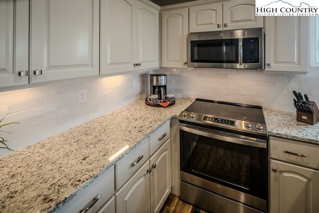 Painted Maple Cabinetry, Custom Tile Backsplash, Under Cabinet Lighting, New Stainless-Steel Appliances | Image 9