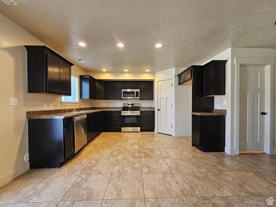 Kitchen with appliances with stainless steel finishes, a textured ceiling, and sink | Image 3