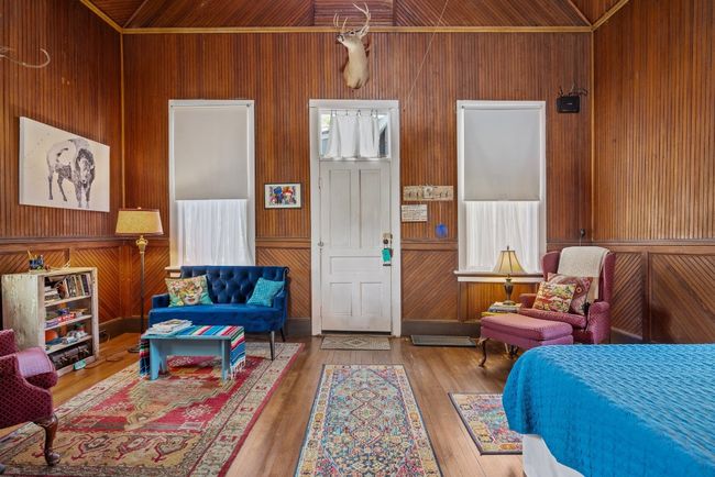 Bedroom with wood walls, hardwood / wood-style flooring, and lofted ceiling | Image 22