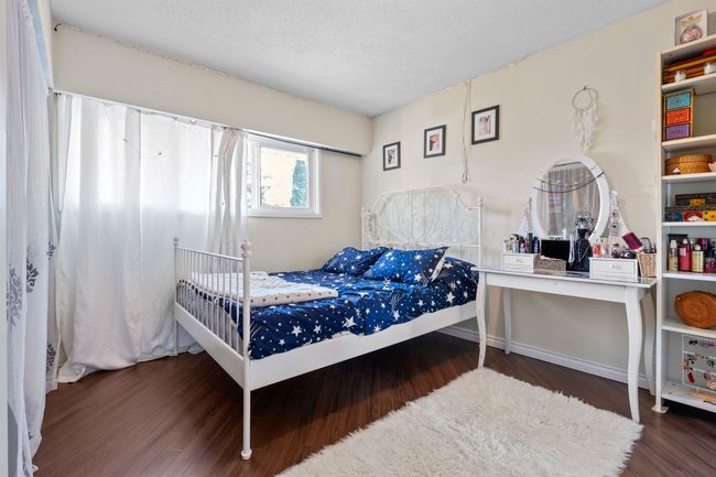 Bedroom with wood finished floors and a textured ceiling | Image 8
