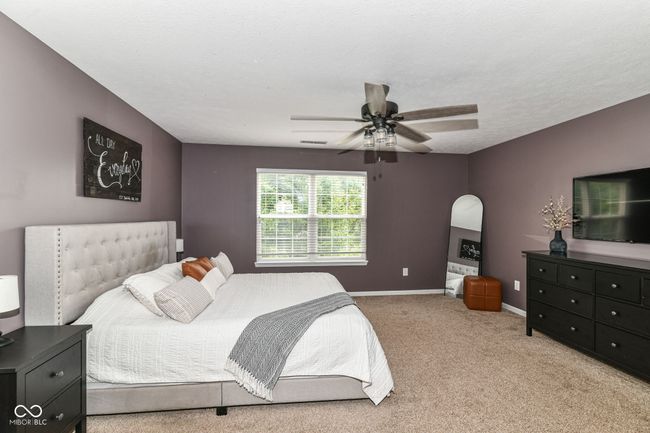 bedroom with carpet floors, arched walkways, baseboards, and ceiling fan | Image 13
