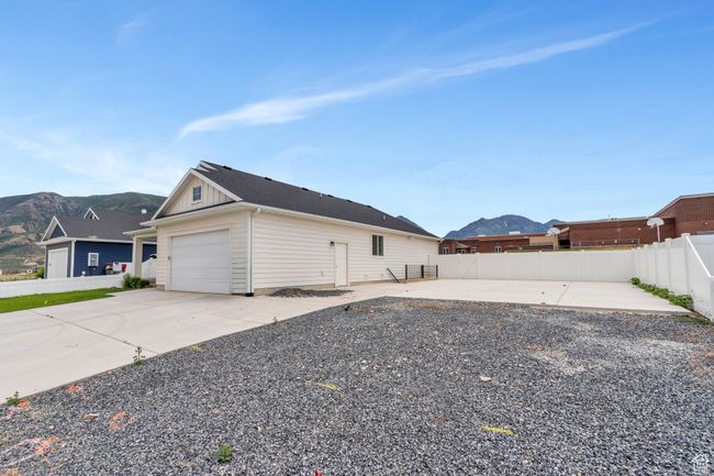 View of home's exterior with a mountain view, board and batten siding, a garage, and driveway | Image 25