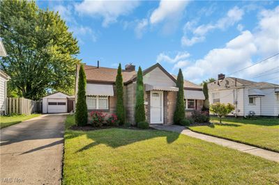 View of front facade, a front yard, and a garage | Image 1