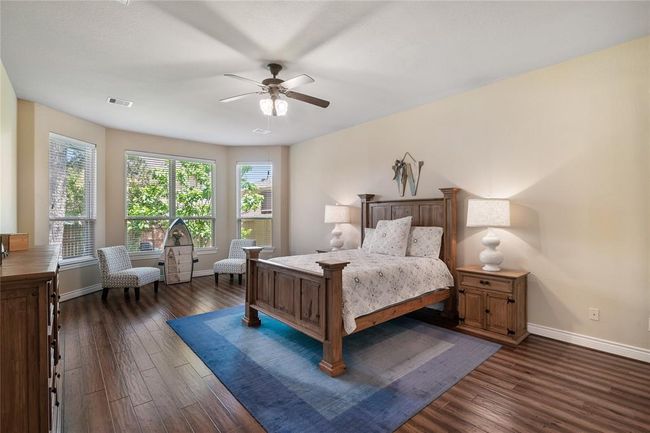 The well-proportioned primary bedroom features a ideally situated sitting area with fabulous engineered wood flooring and a bright view. | Image 18