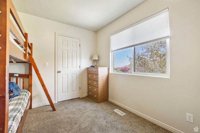 Carpeted bedroom featuring baseboards and visible vents | Image 24