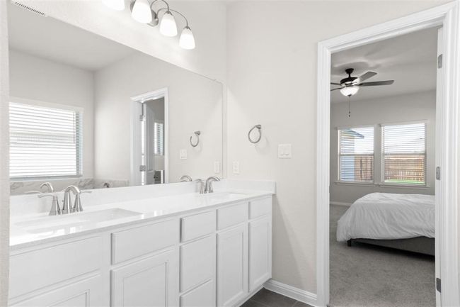 Ensuite bathroom featuring a ceiling fan, a sink, double vanity, and visible vents | Image 25