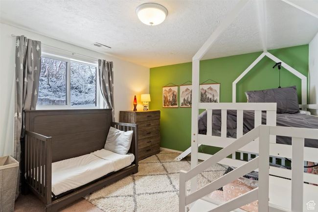 Carpeted bedroom with a textured ceiling and baseboards | Image 28