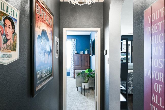 Corridor featuring a chandelier, a textured wall, and carpet floors | Image 12