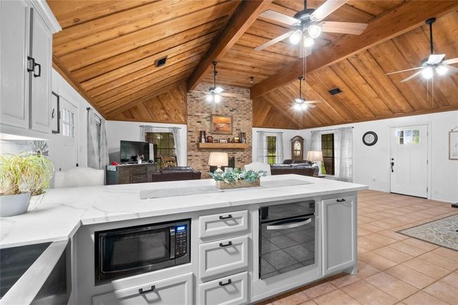 A traditional farmhouse kitchen features soft-close drawers, a hideaway trash cabinet and under the counter microwave. | Image 7