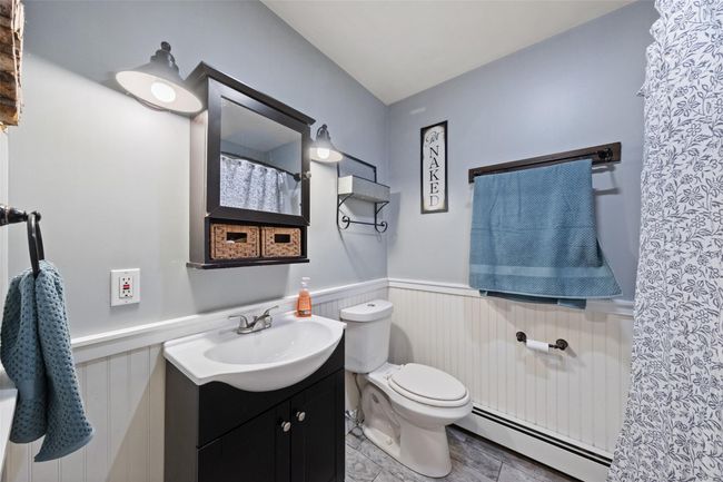 Bathroom featuring wainscoting, toilet, vanity, and a baseboard radiator | Image 21