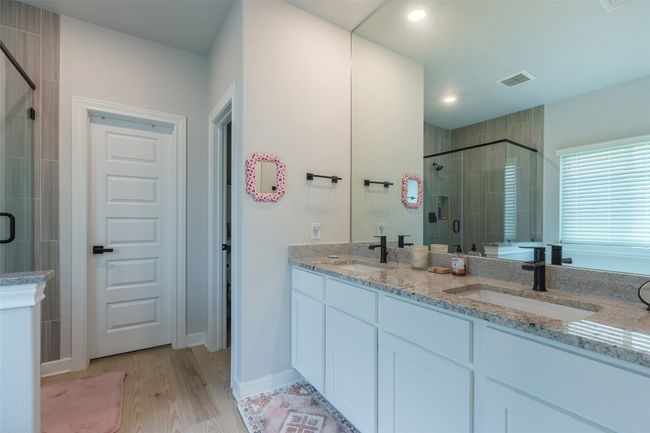 Bathroom with a stall shower, double vanity, wood finished floors, and recessed lighting | Image 16