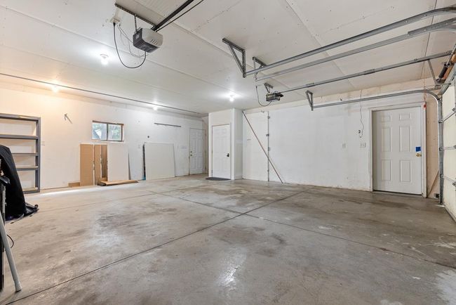 The attached garage shows access to the home (right) access to the finished loft (left) and access to the back patio/backyard | Image 48