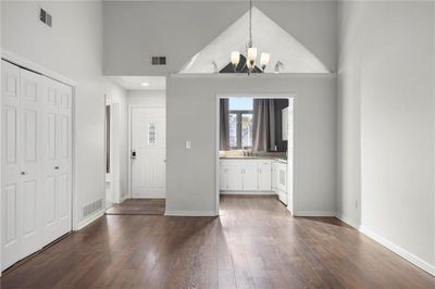 Entryway with high vaulted ceiling, dark hardwood / wood-style flooring, and an inviting chandelier | Image 2