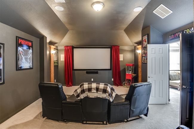 Home theater featuring a textured ceiling, carpet, and lofted ceiling | Image 35