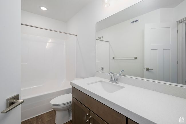Full bath with vanity, wood finished floors, visible vents, toilet, and shower / bathtub combination | Image 16