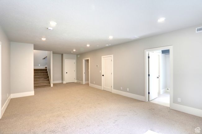 Unfurnished living room featuring light carpet, stairs, and recessed lighting | Image 36