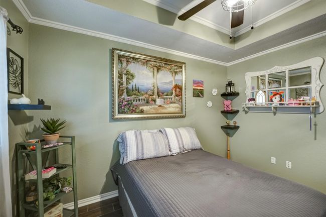Bedroom featuring baseboards, crown molding, and wood finished floors | Image 19