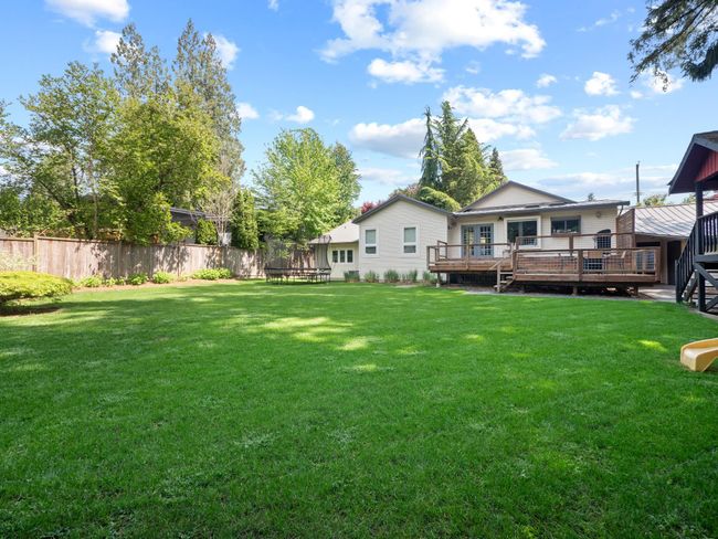 View of yard featuring a trampoline and a deck | Image 35