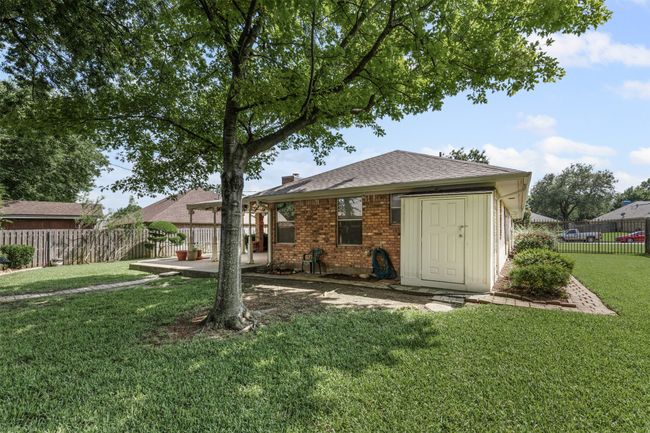 Back of property with storage area and large fenced in yard. | Image 21