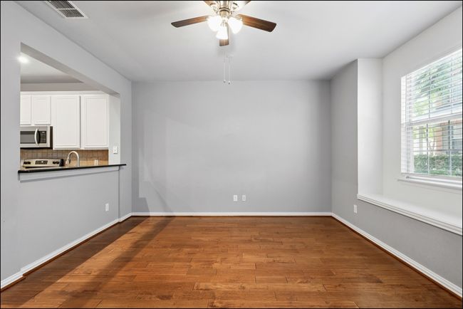 Unfurnished Living room area with baseboards, ceiling fan, visible vents, and wood finished floors | Image 6