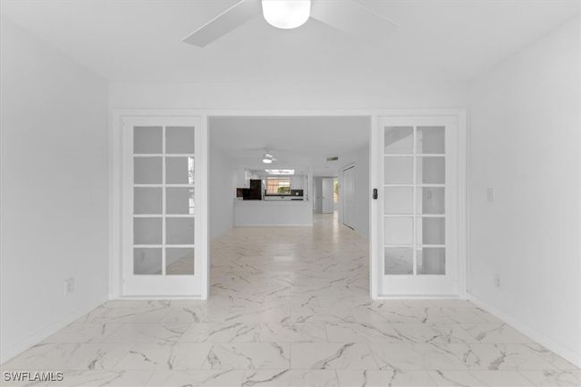 Tiled empty room featuring ceiling fan and french doors | Image 23
