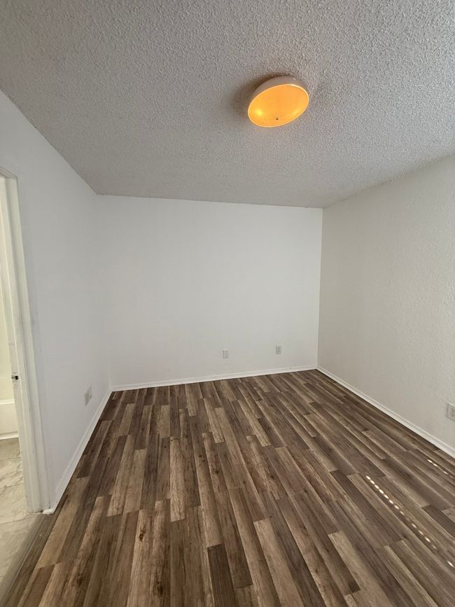 Spare room with dark wood-type flooring and a textured ceiling | Image 11