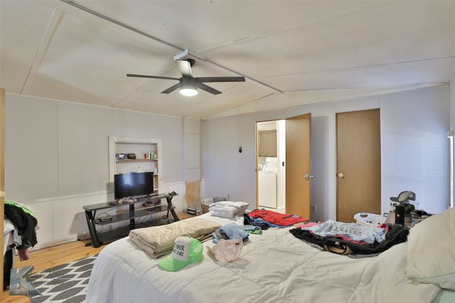 Bedroom with washer / dryer, ceiling fan, lofted ceiling, and wood finished floors | Image 31