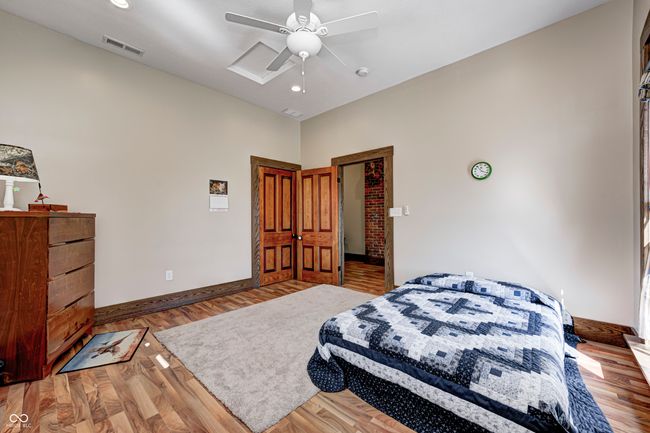 bedroom featuring wood finished floors, ceiling fan, baseboards, and visible vents | Image 38