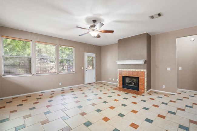 Living room with tile, ceiling fan, and fireplace | Image 12