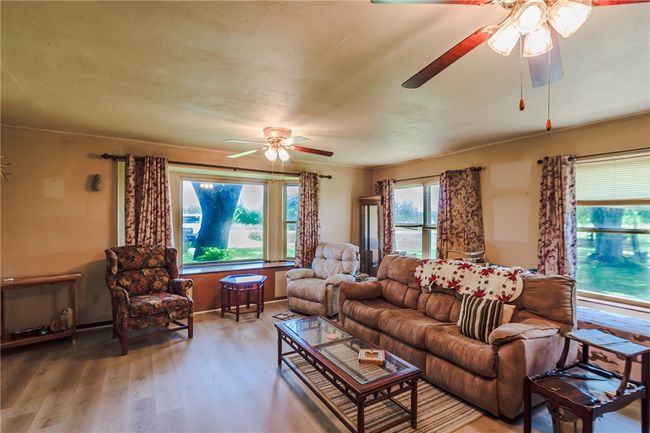 Living room featuring a ceiling fan and wood finished floors | Image 13