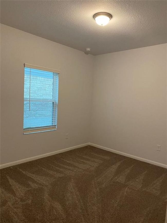 Unfurnished room with dark carpet, a textured ceiling, and baseboards | Image 10