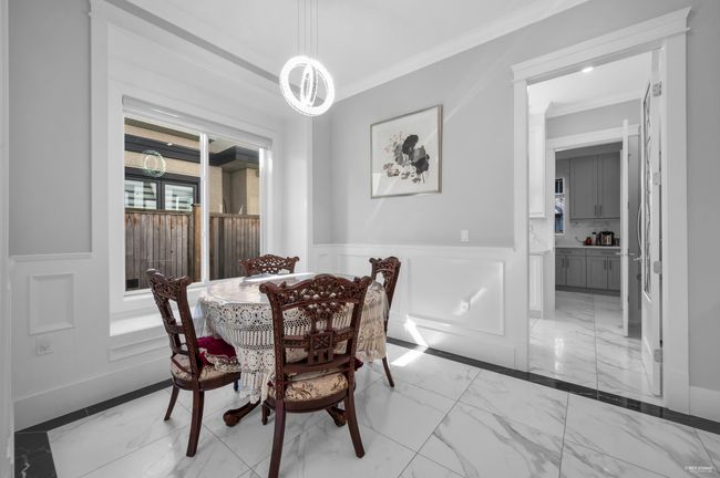 Dining space featuring light marble finish flooring, ornamental molding, wainscoting, and a decorative wall | Image 9