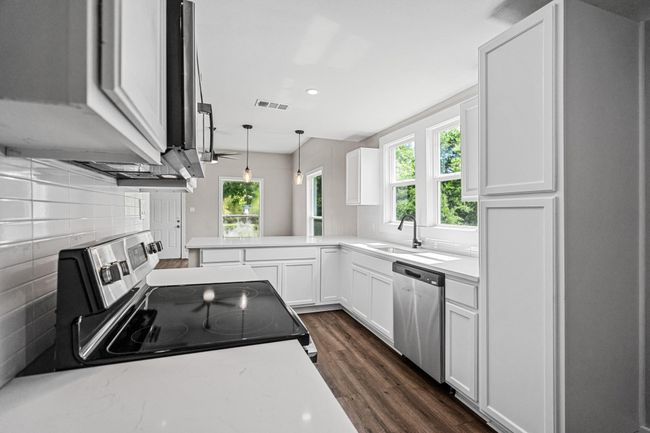 Kitchen with stainless steel appliances, decorative backsplash, plenty of natural light, light countertops, and recessed lighting | Image 8