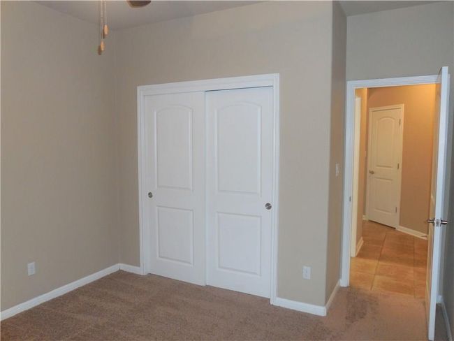 Unfurnished bedroom with a closet, baseboards, and carpet flooring | Image 14