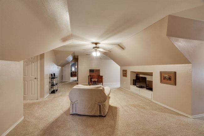 Additional living space with carpet floors, a ceiling fan, built in features, and baseboards | Image 27