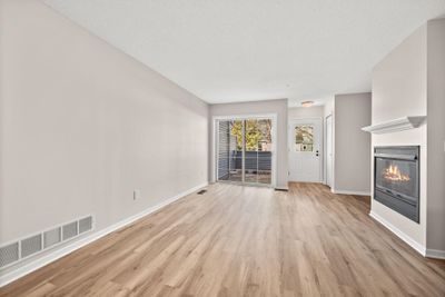 Sizable family room with fresh paint, new LVP flooring and cozy gas fireplace | Image 3