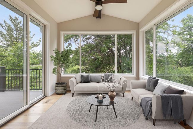 Virtually Staged- Sunroom is bright with 3 walls of windows and vaulted with attractive beam and ceiling fan | Image 21