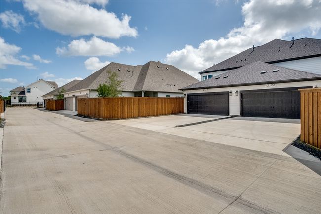 View of property exterior with a residential view, a shingled roof, and concrete driveway | Image 29