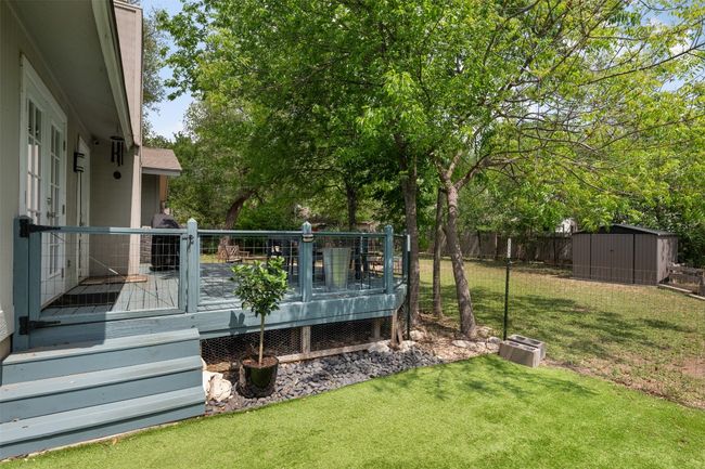 View of yard with an outdoor structure, fence, a deck, and a storage shed | Image 24