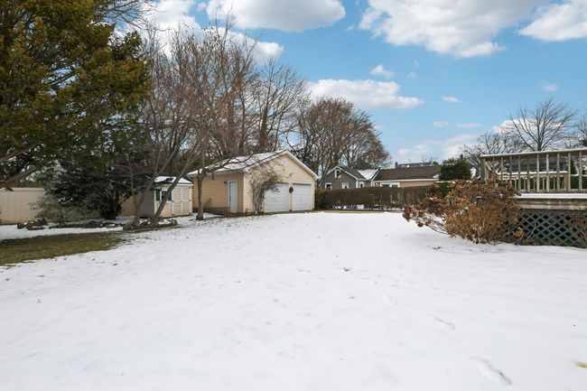 Yard covered in snow with a garage, an outbuilding, and a sunroom | Image 30
