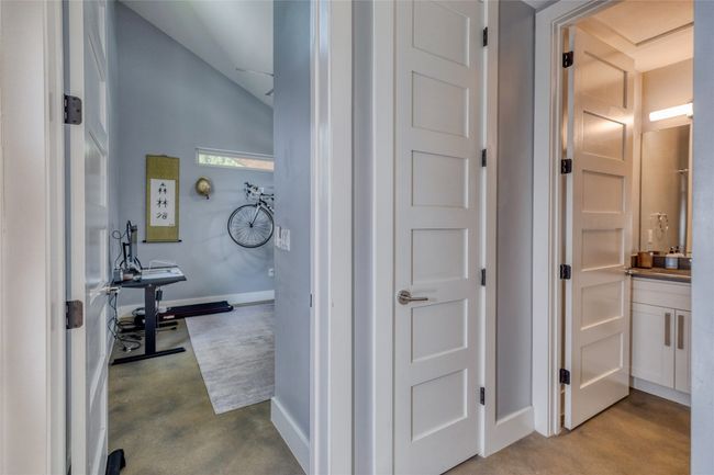 Hall featuring concrete floors, vaulted ceiling, and baseboards | Image 15