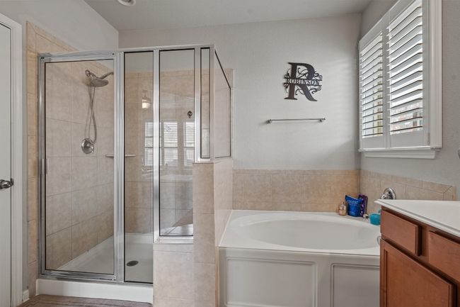 Bathroom featuring a garden tub, a shower stall, and vanity | Image 21