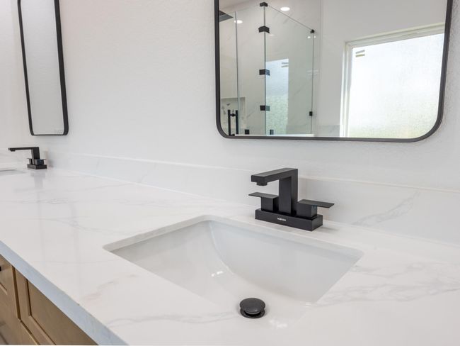 Stylish matte black faucets and frameless black-rimmed mirrors elevate the contemporary design, offering clean lines and high-end functionality. | Image 24