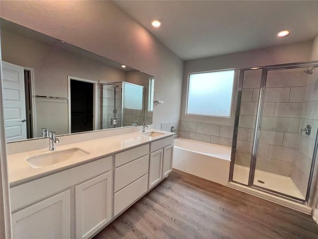 Full bath featuring a shower stall, a garden tub, wood finished floors, double vanity, and recessed lighting | Image 6