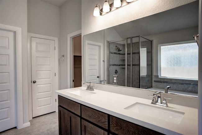 Full bath with tile patterned floors, a sink, double vanity, and a stall shower | Image 22