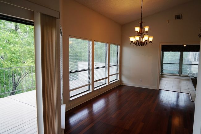 Spare room featuring vaulted ceiling, a chandelier, dark wood finished floors, and baseboards | Image 8