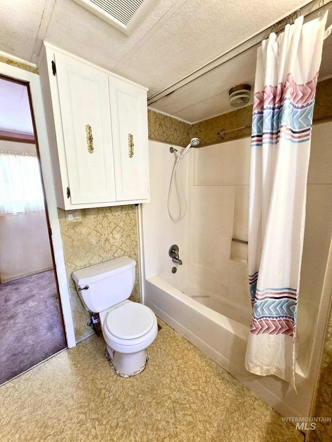 Bathroom featuring shower / tub combo with curtain and tile patterned floors | Image 13
