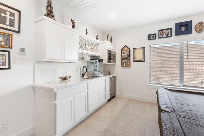 Elegant upstairs wet bar featuring a sleek beverage refrigerator for convenient entertaining. | Image 34