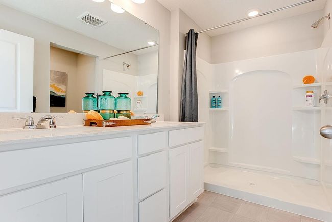 Primary bath offers raised vanity with Quartz counters and 2 sinks. Photo of model home, color & options will vary. | Image 15